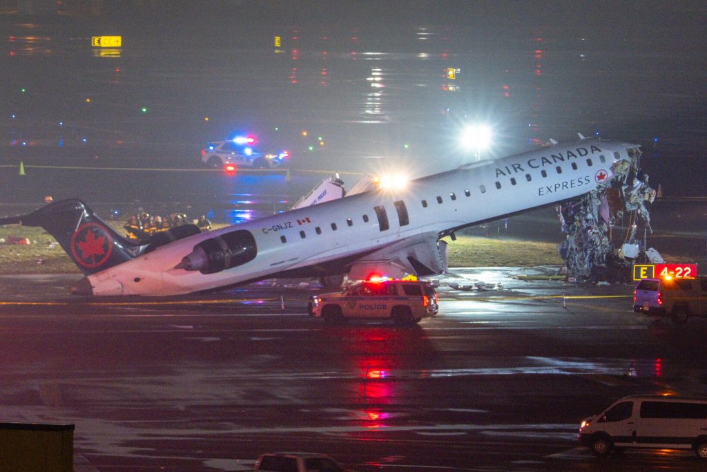 Air Canada Express plane crashes at LaGuardia Airport, killing two pilots. Flight attendant survives after being ejected from CRJ-900, dozens injured.